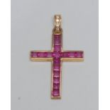 A ruby and diamond cross pendant, channel set with sixteen square baguette cut pinky red rubies, (