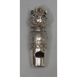 A silver novelty whistle, as the head of a cat, the eyes set with emeralds, 4cm long, marked