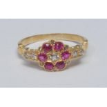A diamond and ruby cluster ring, central oval mixed old cut diamond surrounded by a ring of six