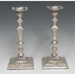 A pair of early George III cast silver table candlesticks, of seamed construction, spirally fluted