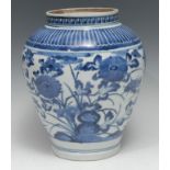 A Japanese ovoid vase, painted in tones of underglaze blue with flowers beneath a lotus border, 27cm