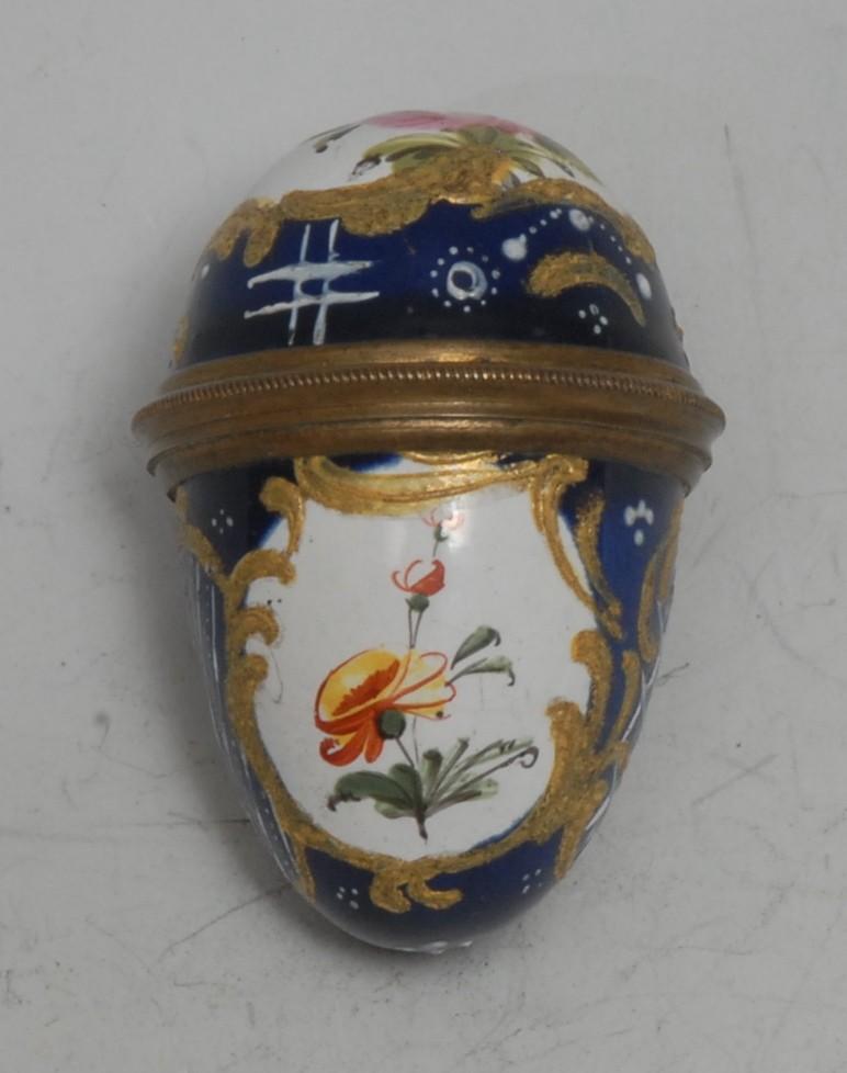 An 18th century South Staffordshire enamel egg shaped bonbonniere, painted with reserves of