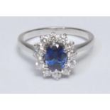 A sapphire and diamond cluster ring, central oval vibrant blue sapphire, approx 1.04ct surrounded by