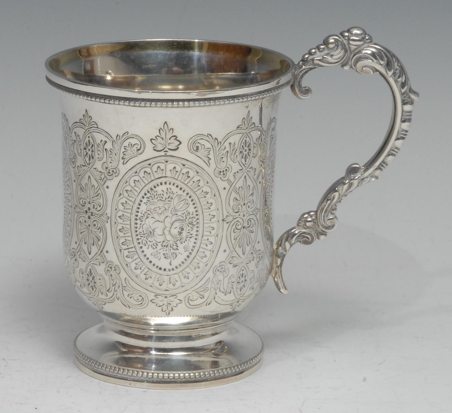 A Victorian silver bell shaped pedestal mug, engraved with flowers, foliage and strapwork, leafy