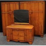 A mid 20th century oak veneered bedroom suite by Austin suite, comprising two double wardrobes and a