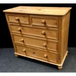 A pine chest of two short drawers over three long, bun feet. 99.5cm high x 105cm wide x 47cm deep.