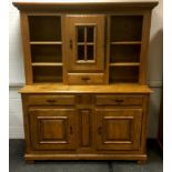 A contemporary oak country kitchen dresser, ogre cornice, central glazed door cupboard over short