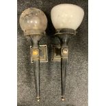 A pair of cast iron exterior wall lights, mismatched shades, 61cm overall