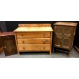 An oak three drawer chest; an oak music cabinet, hinged cover, fall front over two door cupboard,