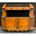 A mahogany wall cabinet with an arrangement of shelves and cupboard, circa 1900