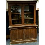 A Victorian oak bookcase cabinet, arched glazed doors enclosing adjustable shelving, two linen