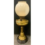 An Art Nouveau brass Juno oil lamp, embossed base and twisting column, opaque glass globular