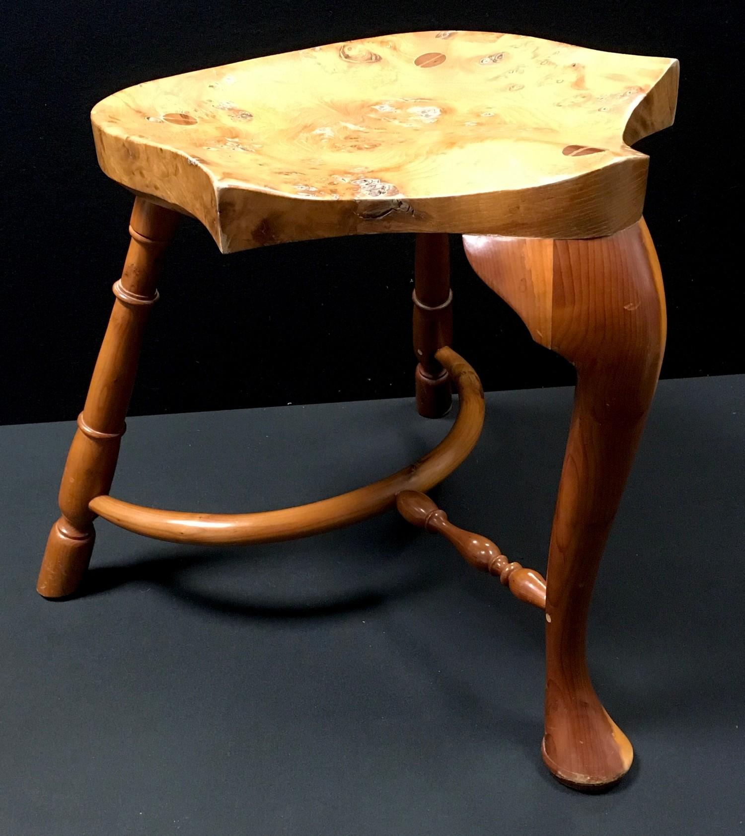 A Stewart Linford burr elm and yew wood stool, shaped saddle seat, cabriole forelegs, turned rear