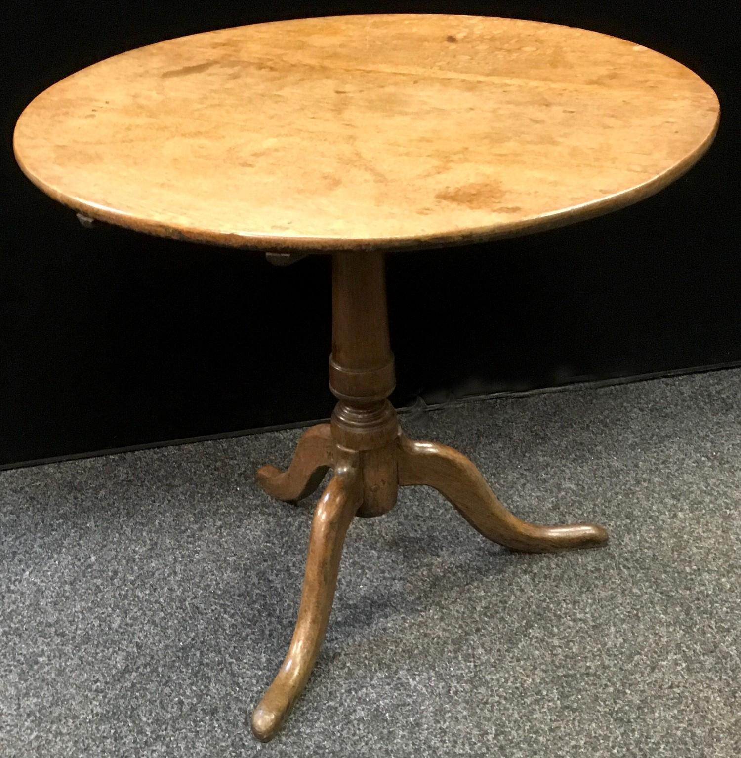 A George III oak tilt-top occasional table, circular top, canon barrel column, cabriole legs. 72.5cm