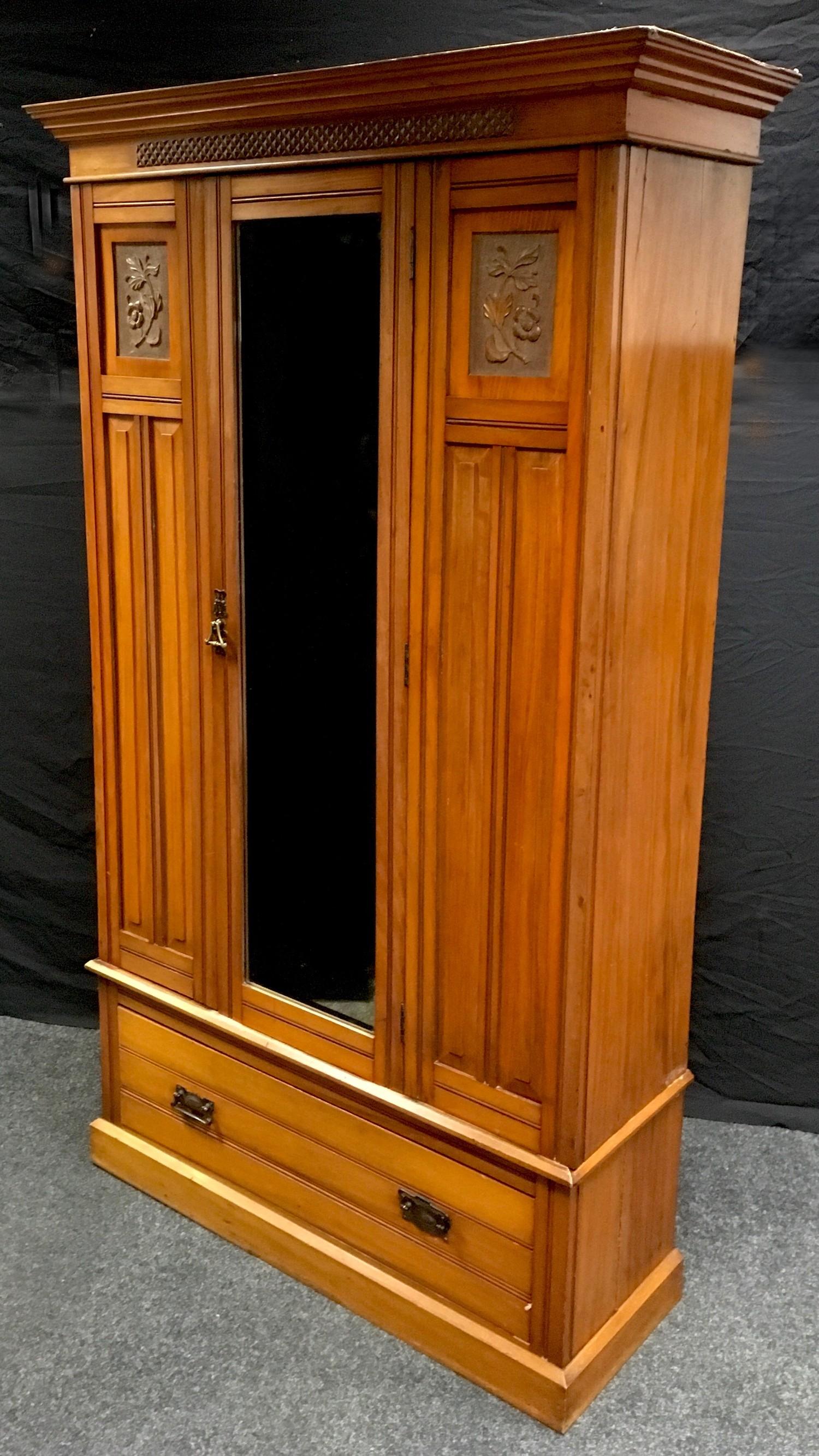 An Edwardian satin walnut wardrobe, stepped cornice, carved frieze, central mirrored door flanked by