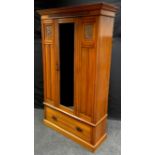 An Edwardian satin walnut wardrobe, stepped cornice, carved frieze, central mirrored door flanked by