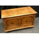 An oak hall seat, hinged cover to top, block fronted panels to front, bun feet. 50cm high x 86cm