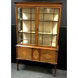 An Edwardian mahogany display cabinet, two glazed doors enclosing lined shelving to the top, two