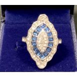 An Art Deco style navette base metal dress ring, set with an arrangement of clear and blue glass