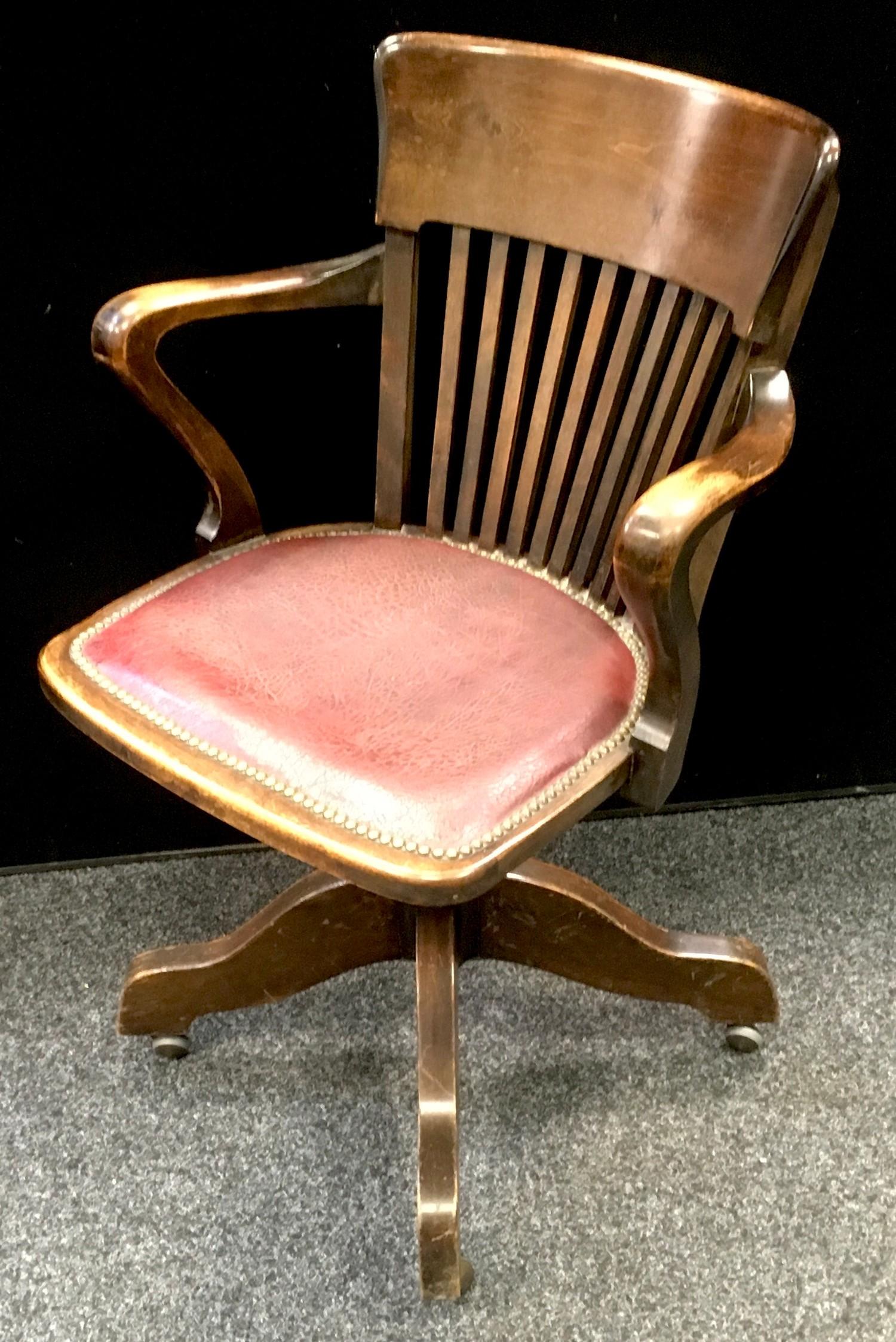 An early 20th century oak office swivel chair.