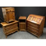 An oak bureau, linenfold panelling to fall front; two oak bedside cabinets; an oak veneered three