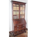 An Art Nouveau mahogany bureau bookcase, outswept cornice above a pair of glazed doors, fall front