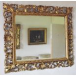 A late 19th century Florentine gilt rectangular mirror, carved and pierced with shell and leafy