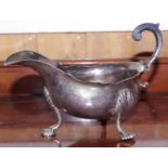 An early George III silver sauceboat, acanthus-capped flying-scroll handle, wavy rim, shell feet,