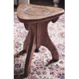 An early 20th century oak stool, rounded triangular seat, three splayed legs, turned finial, c.