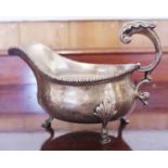 A George V silver sauceboat, acanthus capped flying-scroll handle, hoof feet with shells to knees,