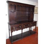 An early 20th century oak dresser, moulded cornice, above open shelves and two enclosed cupboards,