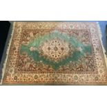 A Super Keshan carpet, central floral medallion within pale green ground, scrolling corner field all