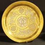 A Persian brass circular tray, applied with script in white metal, picked out in copper, 34.5cm