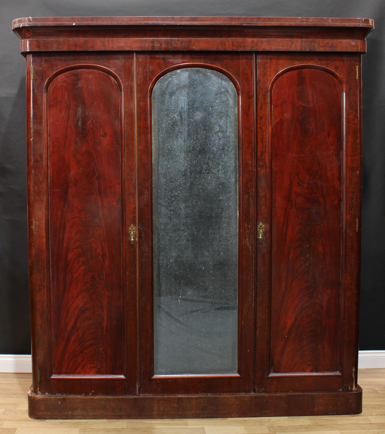 A Victorian mahogany two-door wardrobe, re-purposed from a three-door, outswept cornice above a pair