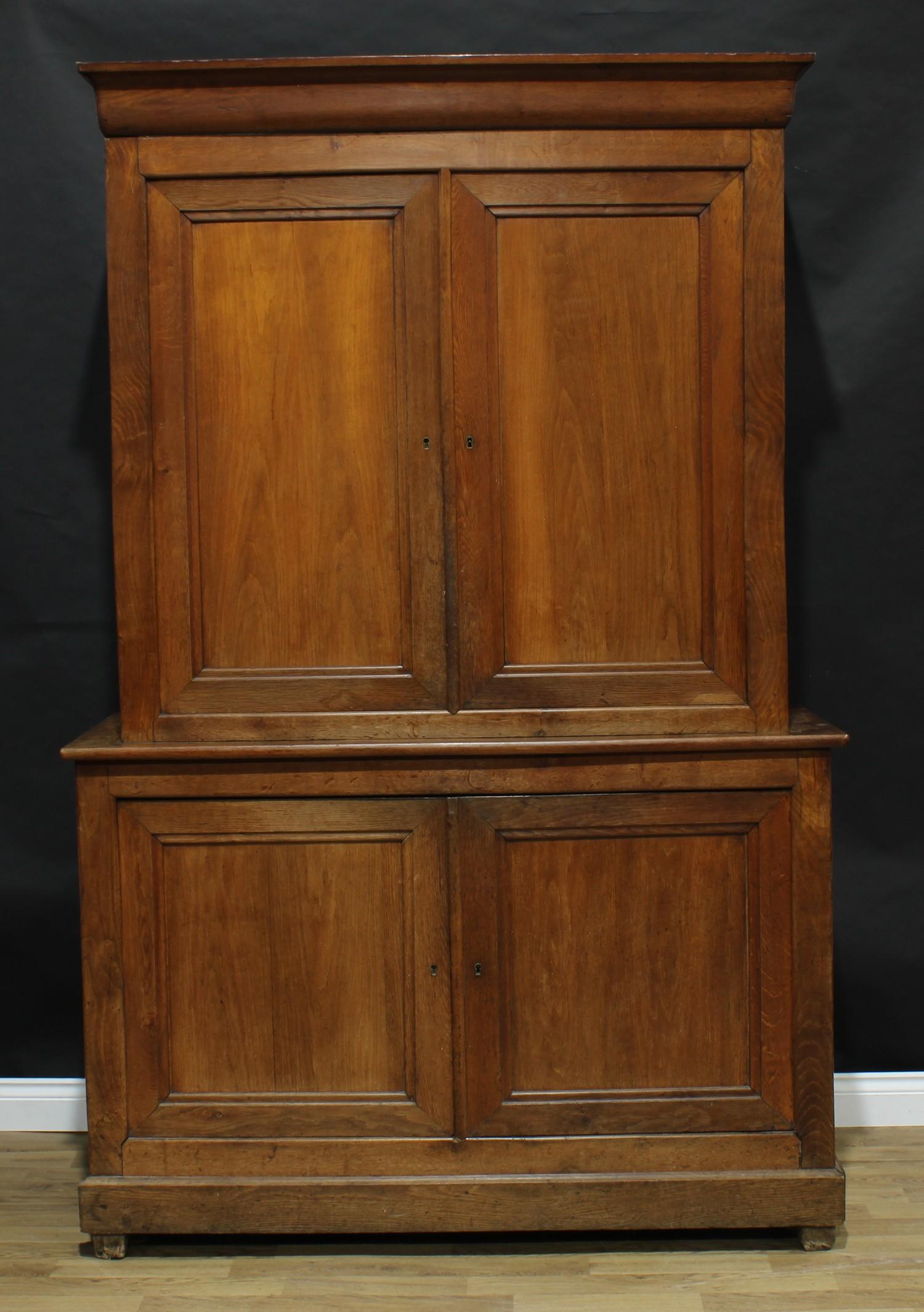 An early 20th century oak housekeeper's cupboard, moulded cornice above a pair of panel doors