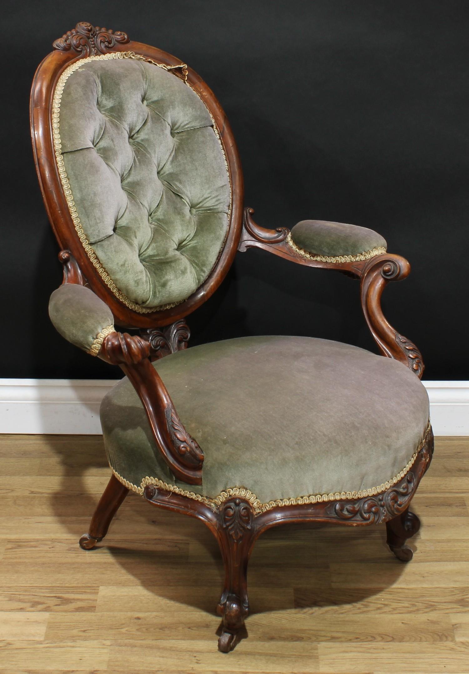 A Victorian walnut boudoir chair, oval back with scrolling foliate cresting, deep-button back, bowed