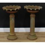 A pair of cast iron garden pedestal planters, each as a squat fluted campana urn, fluted pillar,