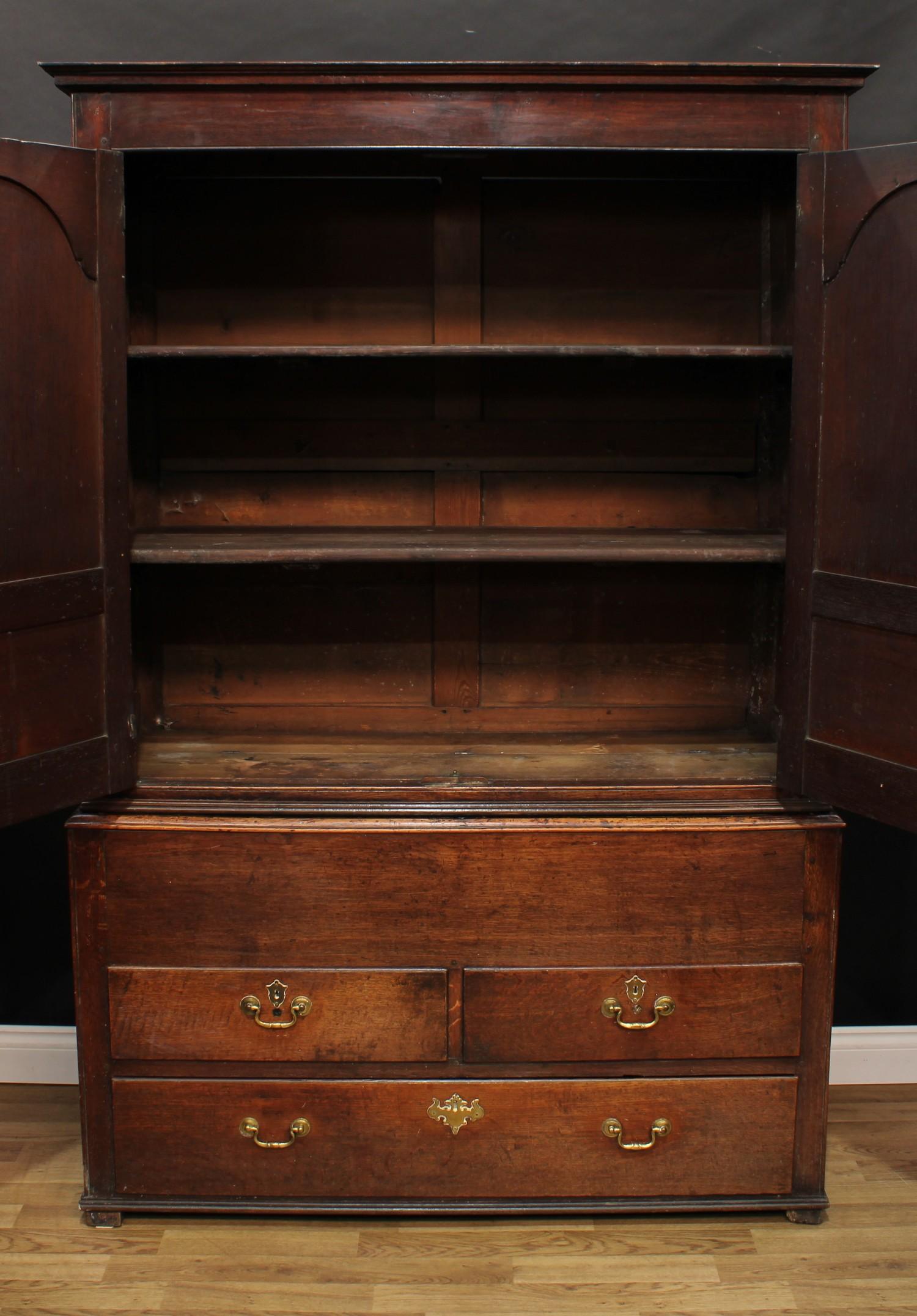 A George III oak housekeeper's or press cupboard, shallow outswept cornice above a pair of raised - Image 2 of 7