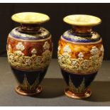 A pair of Doulton Lambeth ovoid stoneware vases decorated by Louisa Wakely, applied in relief with a