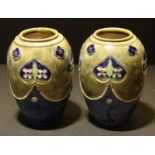 A pair of Royal Doulton stoneware ovoid vases, decorated by Minnie Webb, tube lined with a garland