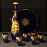A Venetian Tre Fuochi glass decanter and six glasses; a Murano blue glass and gilt circular tray,