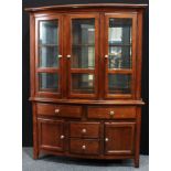 A contemporary bookcase/display cabinet, outswept cornice above three glazed doors enclosing