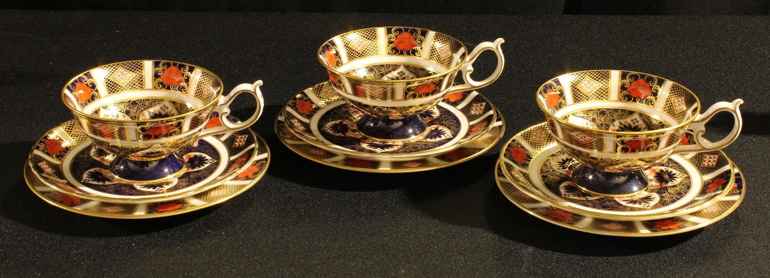 A set of three Royal Crown Derby 1128 pattern cups, saucers and side plates, first quality