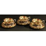 A set of three Royal Crown Derby 1128 pattern cups, saucers and side plates, first quality