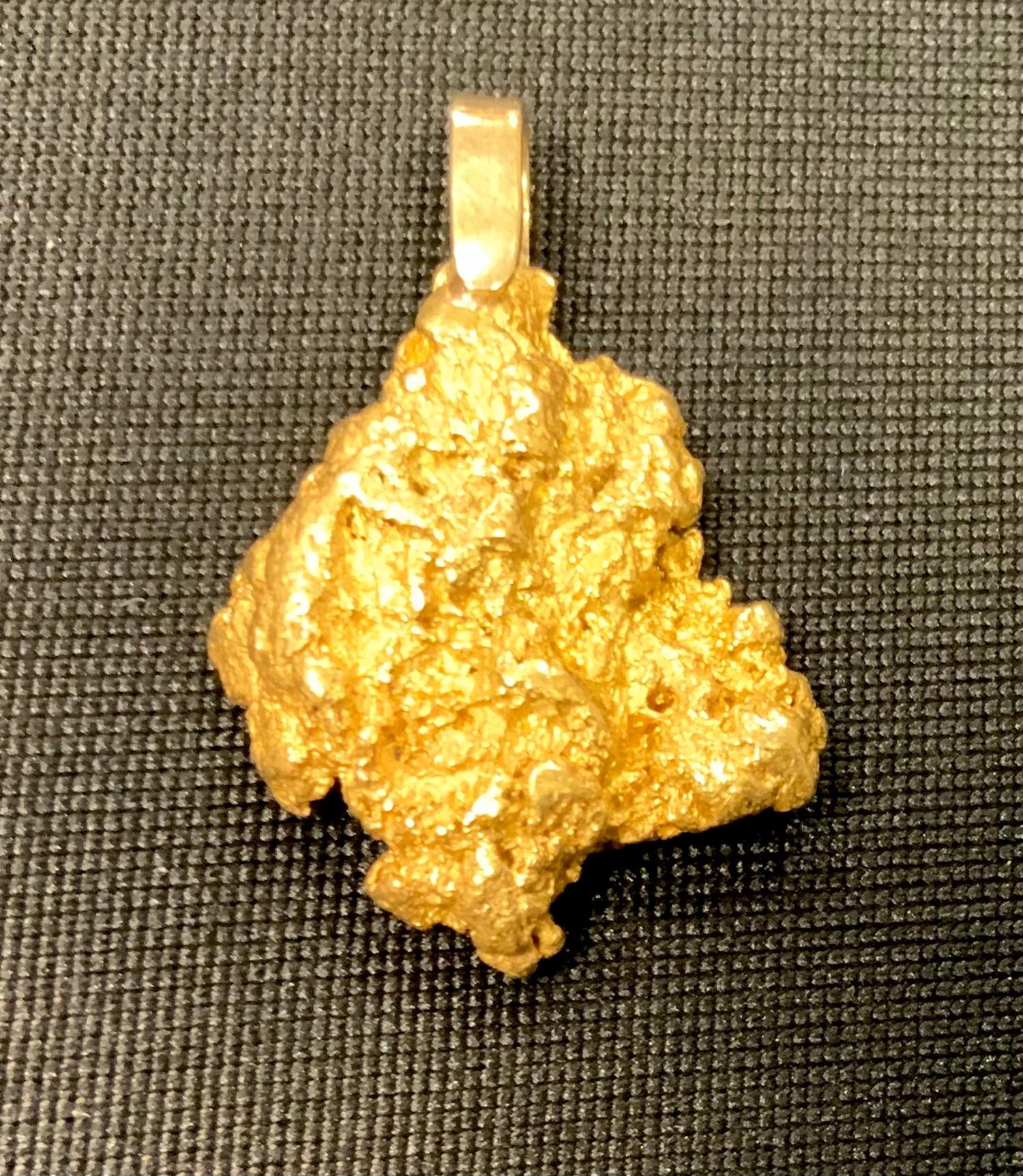 A natural gold nugget as a pendant mounted with a yellow metal hoop 11.7g