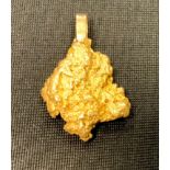 A natural gold nugget as a pendant mounted with a yellow metal hoop 11.7g