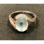 An 18ct white gold twist ring, claw set oval Aquamarine