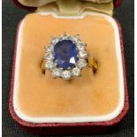 A sapphire & diamond cluster ring, the central oval pale blue sapphire measuring approx 9.67mm x 7.