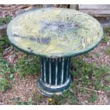 A reconstituted stone oriental garden table, the top cast with fanciful dragons. 56cm high x 59cm