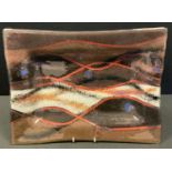 A large Stephanie J Bowen (British 20th Century) oblong glass dish in brown, red, blue, black &